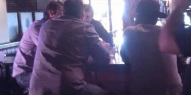 Friends in conversation over drinks at a dimly lit bar